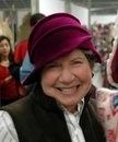 a woman wearing a purple hat and smiling.