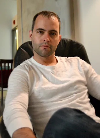 A man sitting in a chair looking at the camera.