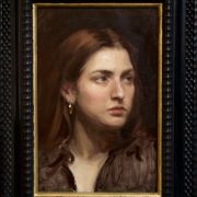 Framed painting of a woman with long brown hair looking to the side, wearing a dark top and gold hoop earring.